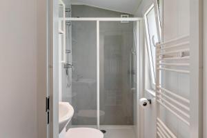 a white bathroom with a shower and a toilet at Janes in Dörverden +21 photos
