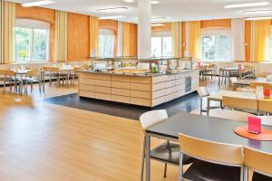 a restaurant with tables and chairs and a counter at Jugendhaus St. Kilian in Miltenberg