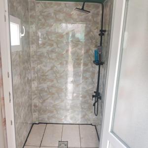 a shower in a bathroom with a stone wall at Evergreen Motto Sohodol Camping in Sohodol