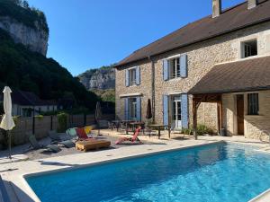 a house with a swimming pool in front of a building at Du Baume Au Cœur in Baume-les-Messieurs
