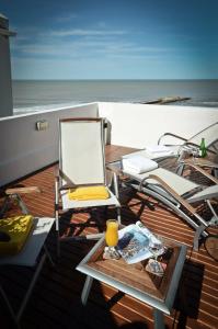 uma cadeira e uma mesa com um copo de sumo de laranja em Hotel Presidente em Mar del Plata