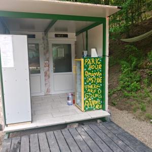 a front door of a building with a sign on it at Evergreen Motto Sohodol Camping in Sohodol