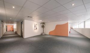 an empty hallway in an office building with a plant at 休日行旅 Vacay Stay in Tainan +17 photos