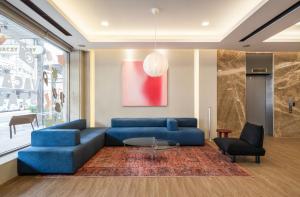 a living room with a blue couch and a table at 休日行旅 Vacay Stay in Tainan
