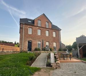 a large brick house with a table in front of it at Wohnen im Klassenzimmer einer Alten Schule in Baustert