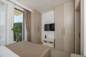 a bedroom with a bed and a large window at Majestic Bay in Čanj