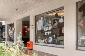 a store window with the words okay to stay at 休日行旅 Vacay Stay in Tainan