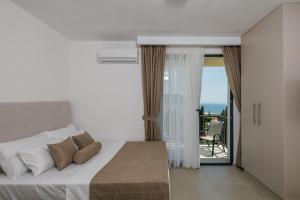 a bedroom with a bed and a view of the ocean at Majestic Bay in Čanj