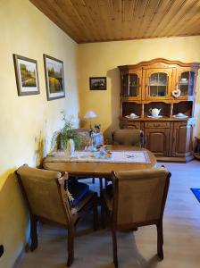 a dining room with a wooden table and chairs at Ferienwohnung Waldblick in Langenfeld