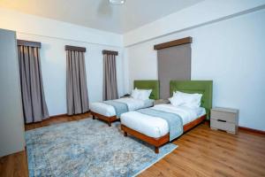 a bedroom with two beds and a rug at Devi Aura Villa in Burhānilkantha +2 photos