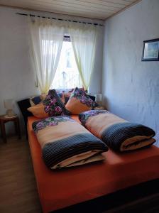 a couch with pillows on it with a window at Ferienwohnung Waldblick in Langenfeld