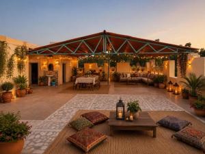 a large outdoor patio with a couch and tables at Hotel Robin Jaisalmer Near fort view in Jaisalmer