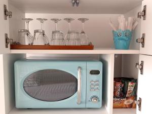 a blue microwave in a shelf with glasses on it at Studio Privat Reea Olimp in Olimp