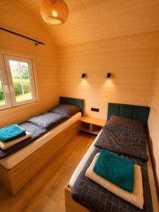 two beds in a room with wooden walls at Osada Pana Kraba in Jarosławiec