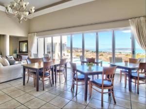 a dining room with tables and chairs and windows at Dunestone Boutique GuestHouse in Langebaan