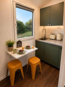a kitchen with a table and two stools and a window at Aktivurlaub im Schwarzwald Natur Sport und Erholung in Efringen-Kirchen