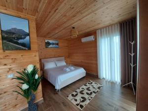 a bedroom with a bed in a wooden room at Villa Sajmo in Koman