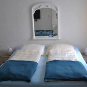 a bed with two pillows in a room with a mirror at Hotel zur Rennvahn in Dortmund
