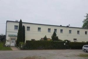 a large white building with a car parked in front of it at Hotel zur Rennvahn in Dortmund