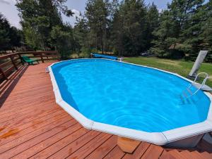 a large swimming pool on a wooden deck at Dom wakacyjny i Domki letniskowe nad Tanwią Roztocze in Narol +51 photos