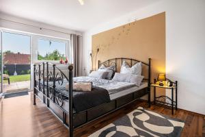 a bedroom with a bed and a large window at Ferienglück Vogelsang in Loßburg