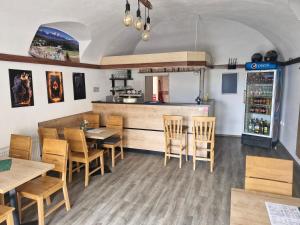 a restaurant with a table and chairs and a bar at Apartmány BRETZ in Vrbov
