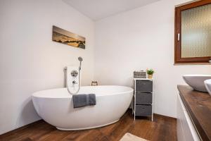 a bathroom with a white tub and a sink at Ferienglück Vogelsang in Loßburg +28 photos