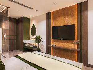 a bedroom with a tv on a wall at Reviah Hotel in Hanoi