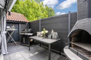 a patio with a table and an outdoor oven at Ferienglück Vogelsang in Loßburg
