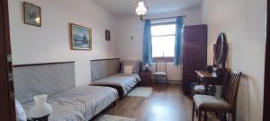 a room with two beds and a window at Felföldi Tanyavendégház in Kiskunmajsa