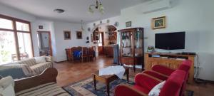 a living room with couches and a flat screen tv at Felföldi Tanyavendégház in Kiskunmajsa