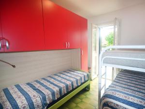 a room with two bunk beds and red cabinets at SIT Holiday Homes in Lido delle Nazioni