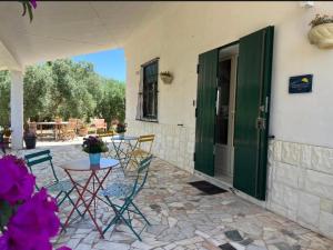 a patio with a table and chairs and a green door at White House R&B in Campobello di Licata