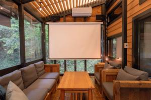a screened in living room with a large screen at Tiny Base in Kawazu