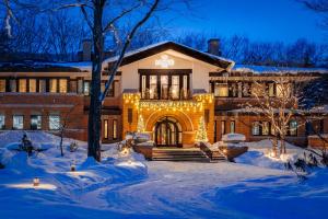 a building with christmas lights in the snow at Hotel La Neige in Hakuba