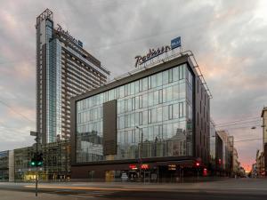 a large building with people sitting on top of it at Radisson Blu Latvija Conference & Spa Hotel, Riga in Riga