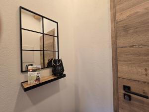 a mirror on a wall with a purse on a shelf at Scheuneria, Gästehaus in Dockweiler