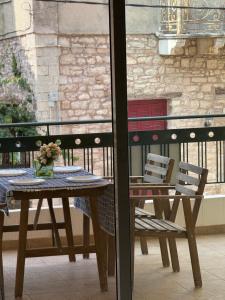 a wooden table and chairs on a balcony at Alasrooms A1 in Missolonghi