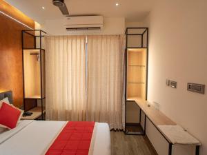 a bedroom with a bed and a desk and a window at Crown Residency in Kanyakumari