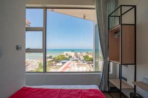 a bedroom with a large window with a view of the ocean at Crown Residency in Kanyakumari