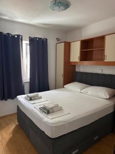 a bedroom with a large bed with blue curtains at Apartment Ćule in Senj
