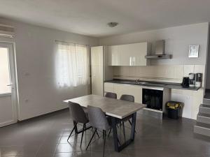 a kitchen with a table and chairs in a room at Apartment Ćule in Senj