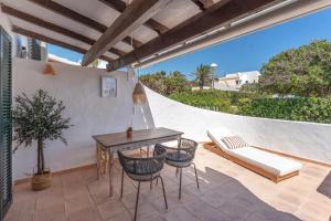 a patio with a table and chairs and a couch at Villas 19 Estrellas in Cala en Bosc