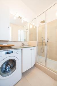 a white washing machine in a bathroom with a shower at Simo House Stunning Lake View Balcony AC in Carate Urio +43 photos