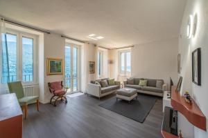 a living room with couches and chairs and windows at Simo House Stunning Lake View Balcony AC in Carate Urio