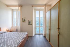 a bedroom with a bed and a large window at Simo House Stunning Lake View Balcony AC in Carate Urio