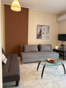 a living room with a couch and a glass table at Alasrooms A1 in Missolonghi