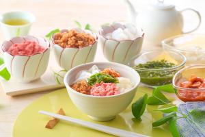 a bowl of food on a table with bowls of food at Ooedo Onsen Monogatari Dogo in Matsuyama