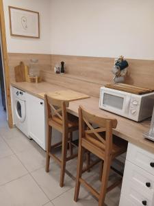 a kitchen with a wooden counter top with a microwave at Apartament Deptak Sądecki in Nowy Sącz