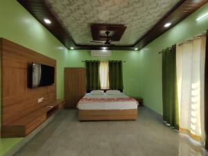 a bedroom with a bed and a flat screen tv at M2 lambardaar in Dehradun